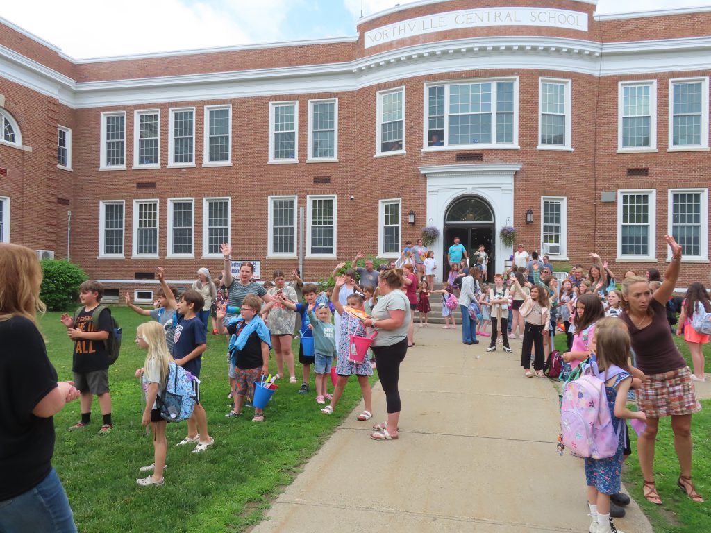 Students waving goodbye on the last day of school